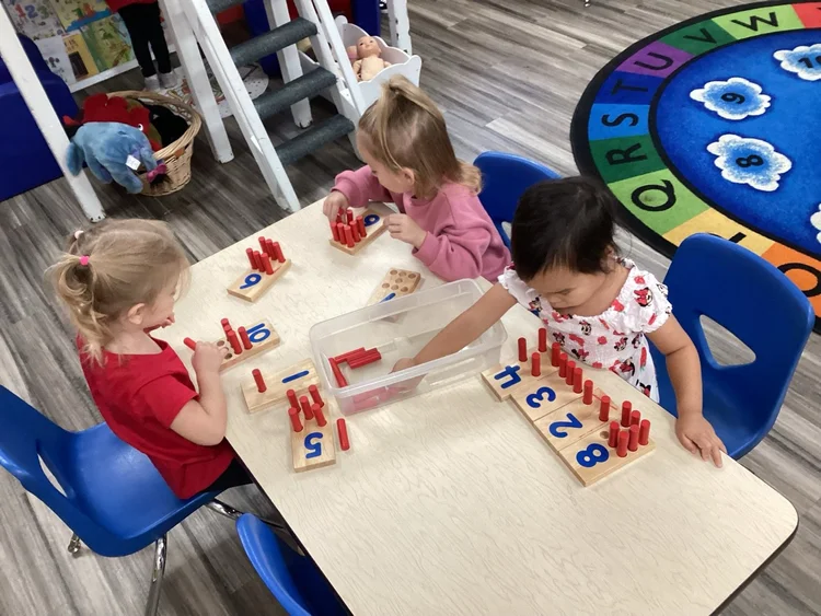 A child working with number rods at a table