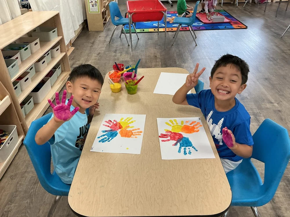 Two boys showing their handprint art