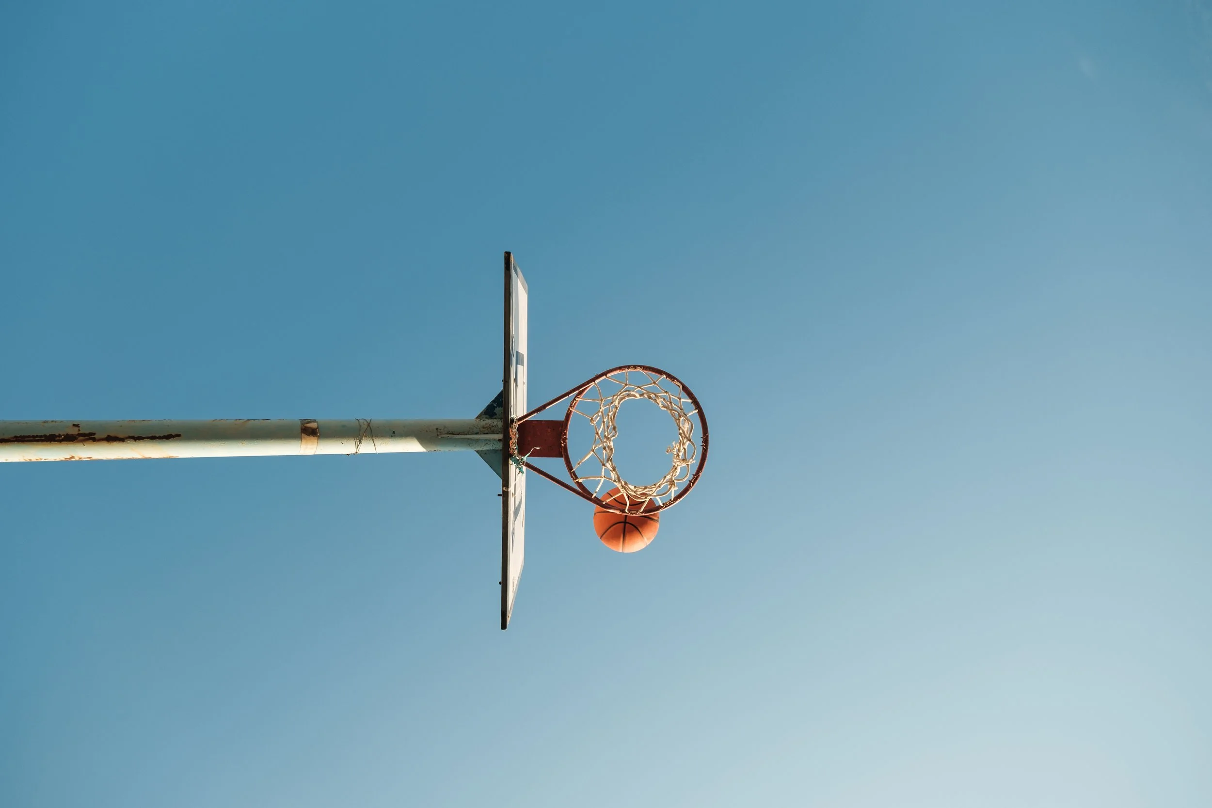 ball-above-basketball-ring-against-blue-sky-2023-11-27-05-16-30-utc.jpg