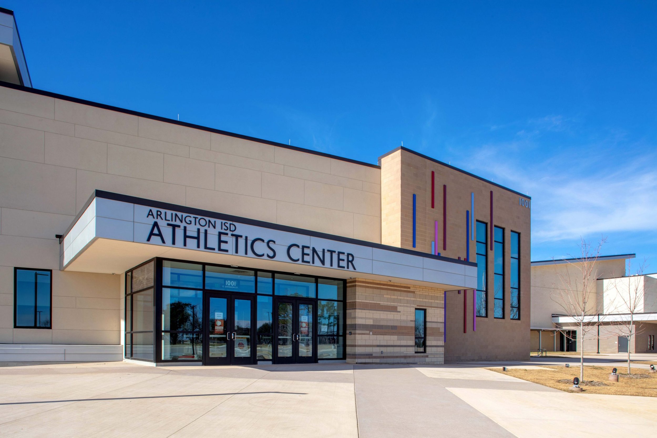 Exterior view of Arlington ISD Athletics Center building with a clear blue sky in the background.