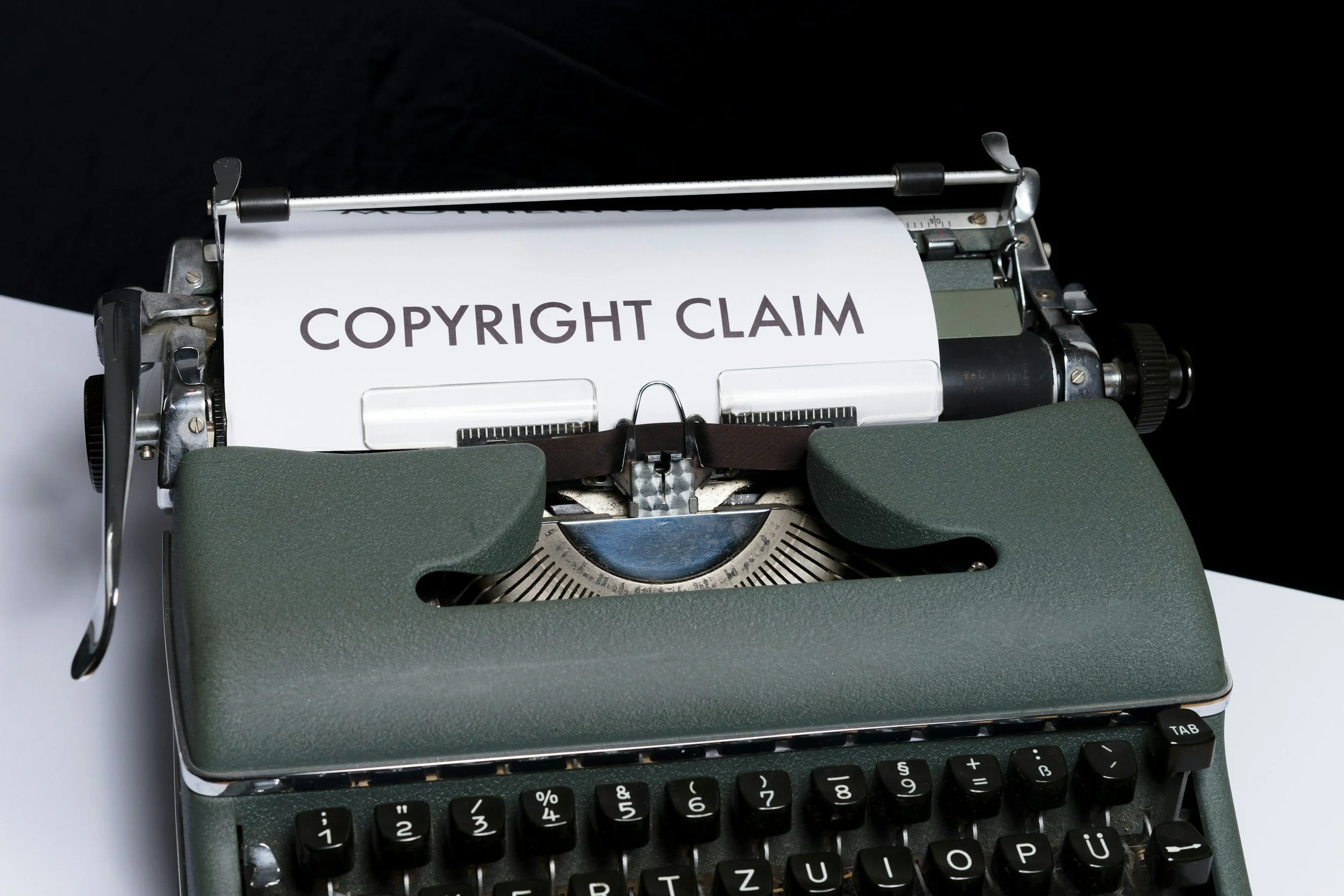 A vintage typewriter with a paper that has 'COPYRIGHT CLAIM' printed on it.