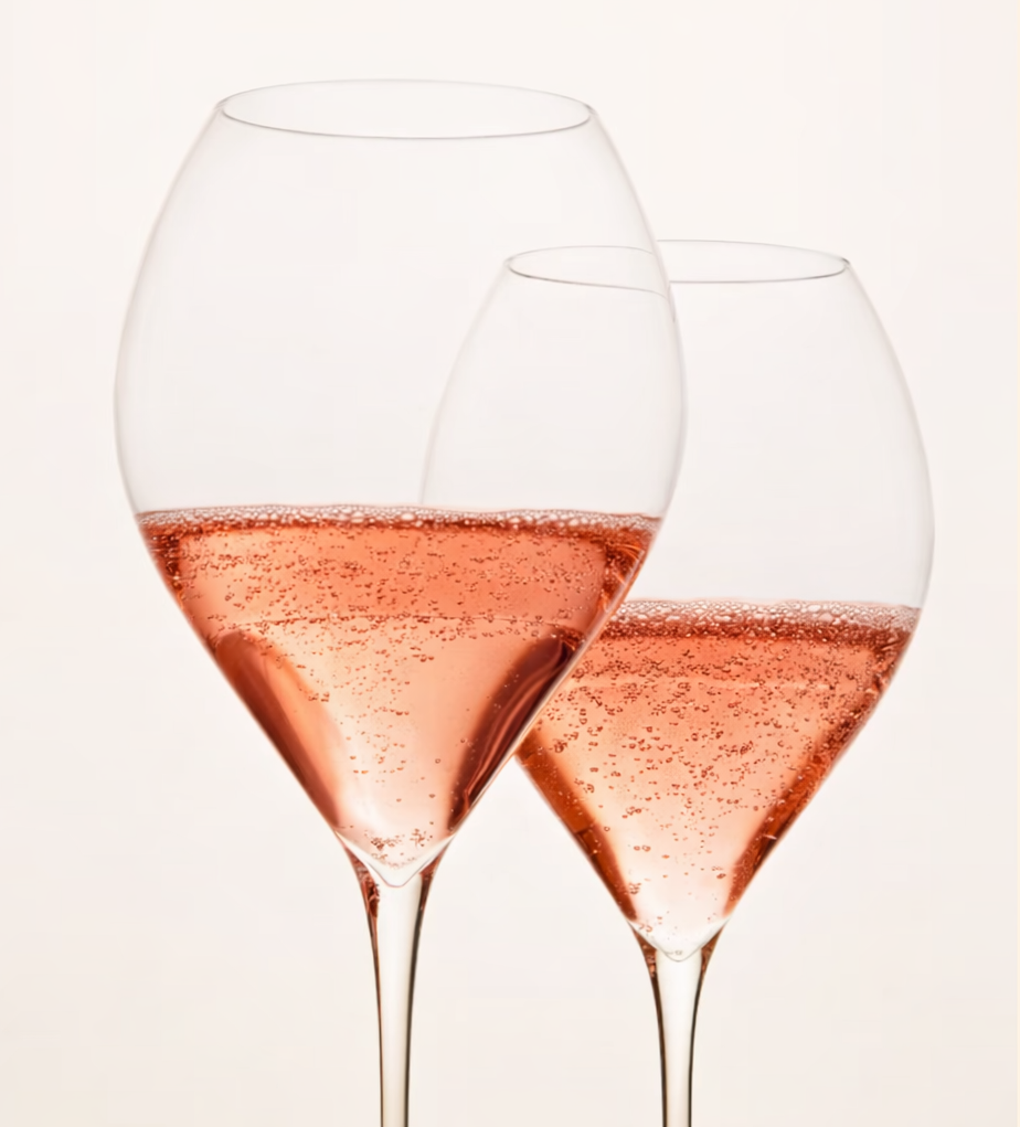Twee wijnglazen gevuld met rosé wijn, tegen een lichte achtergrond.