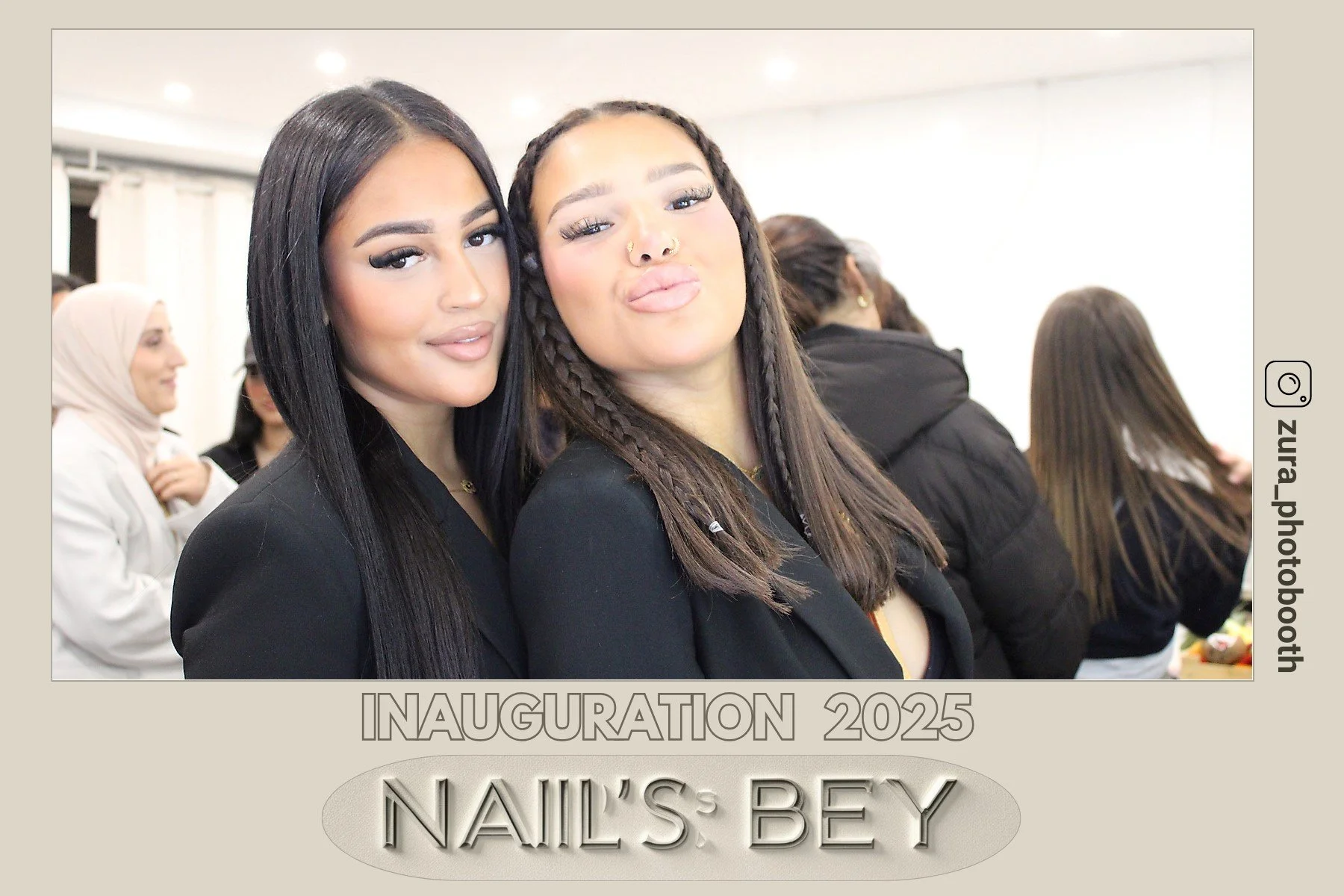 Deux jeunes femmes souriantes posant pour une photo lors d'une inauguration 2025 Nail's Bey, avec d'autres personnes en arrière-plan dans une salle bien éclairée.