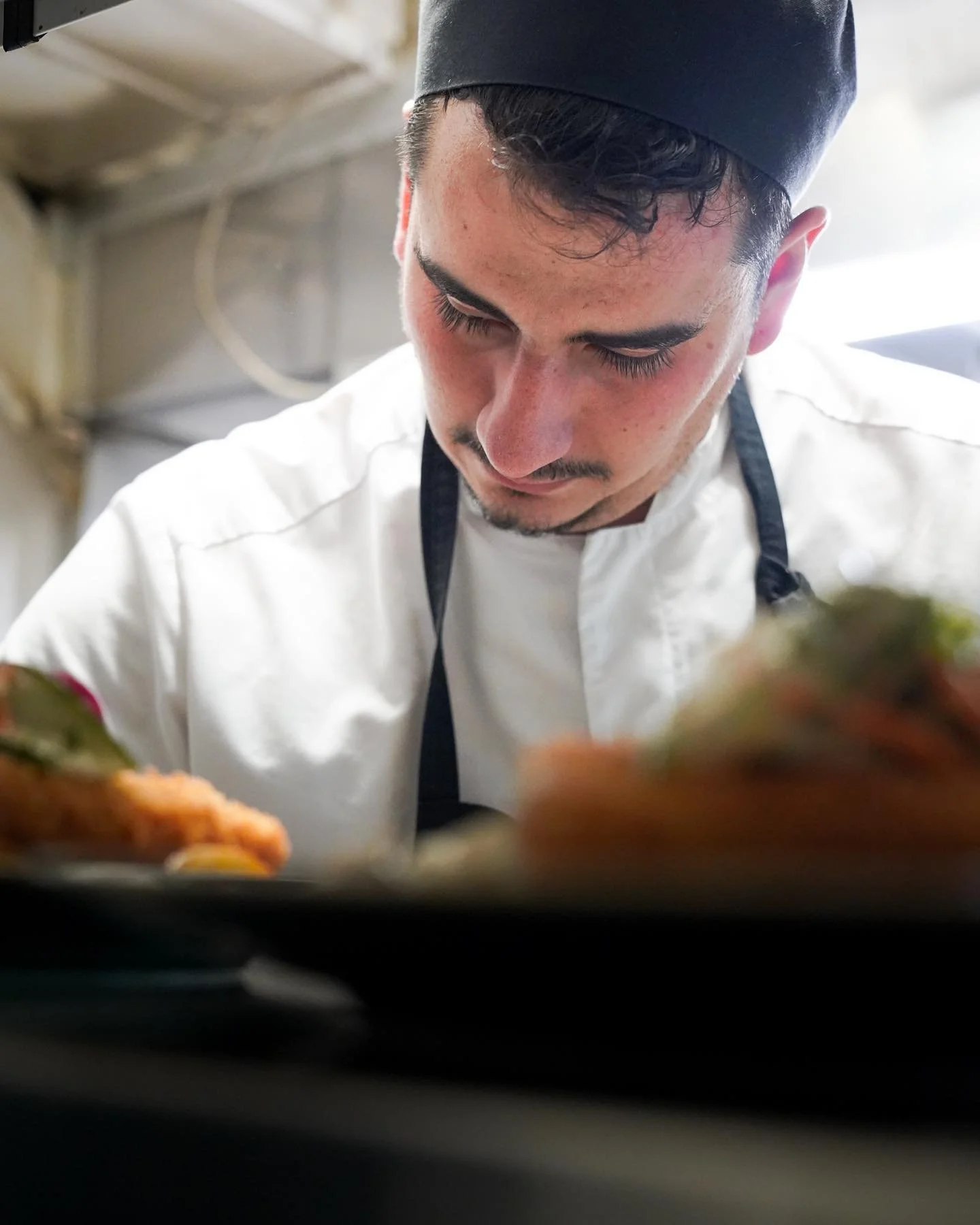 Kock som förbereder flera portioner catering i restaurangkök
