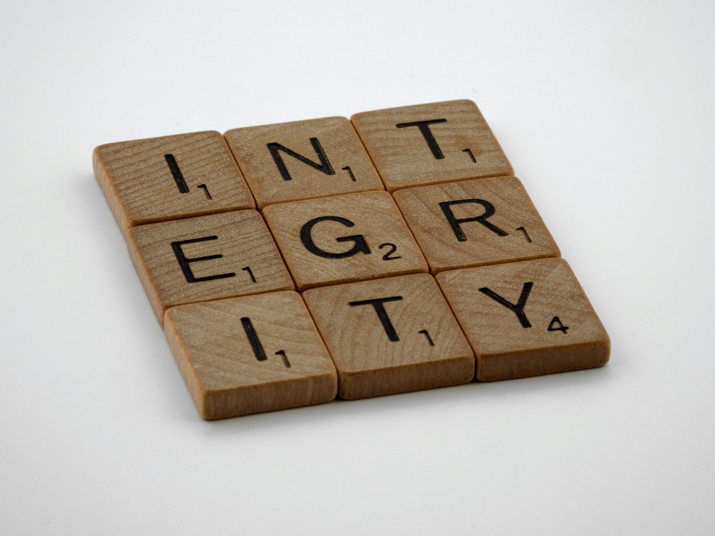 Scrabble tiles arranged to spell 'INTEGRITY' on a plain white background.