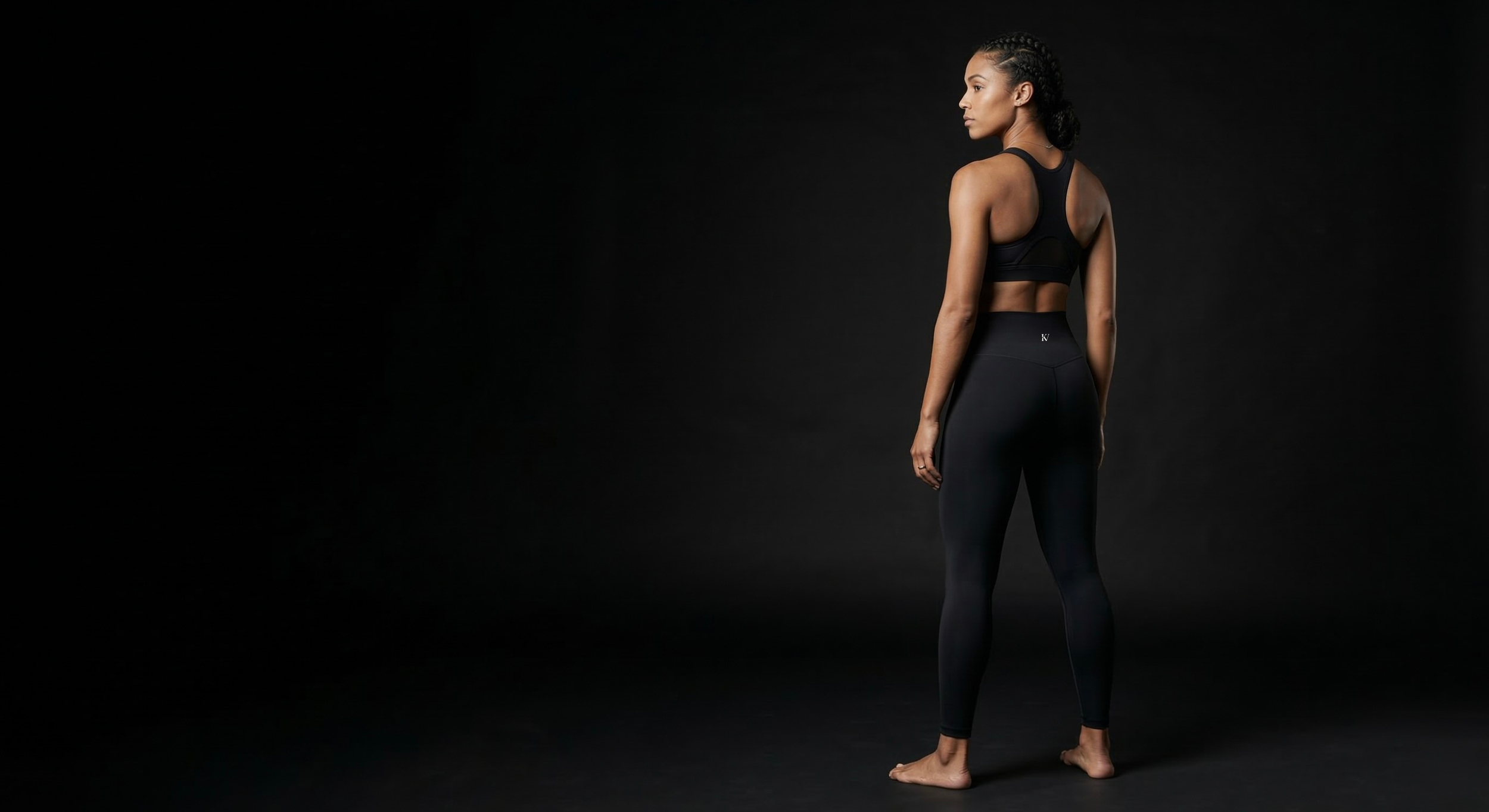 KAVERA legging rear view — model turned to side, structured waistband silhouette