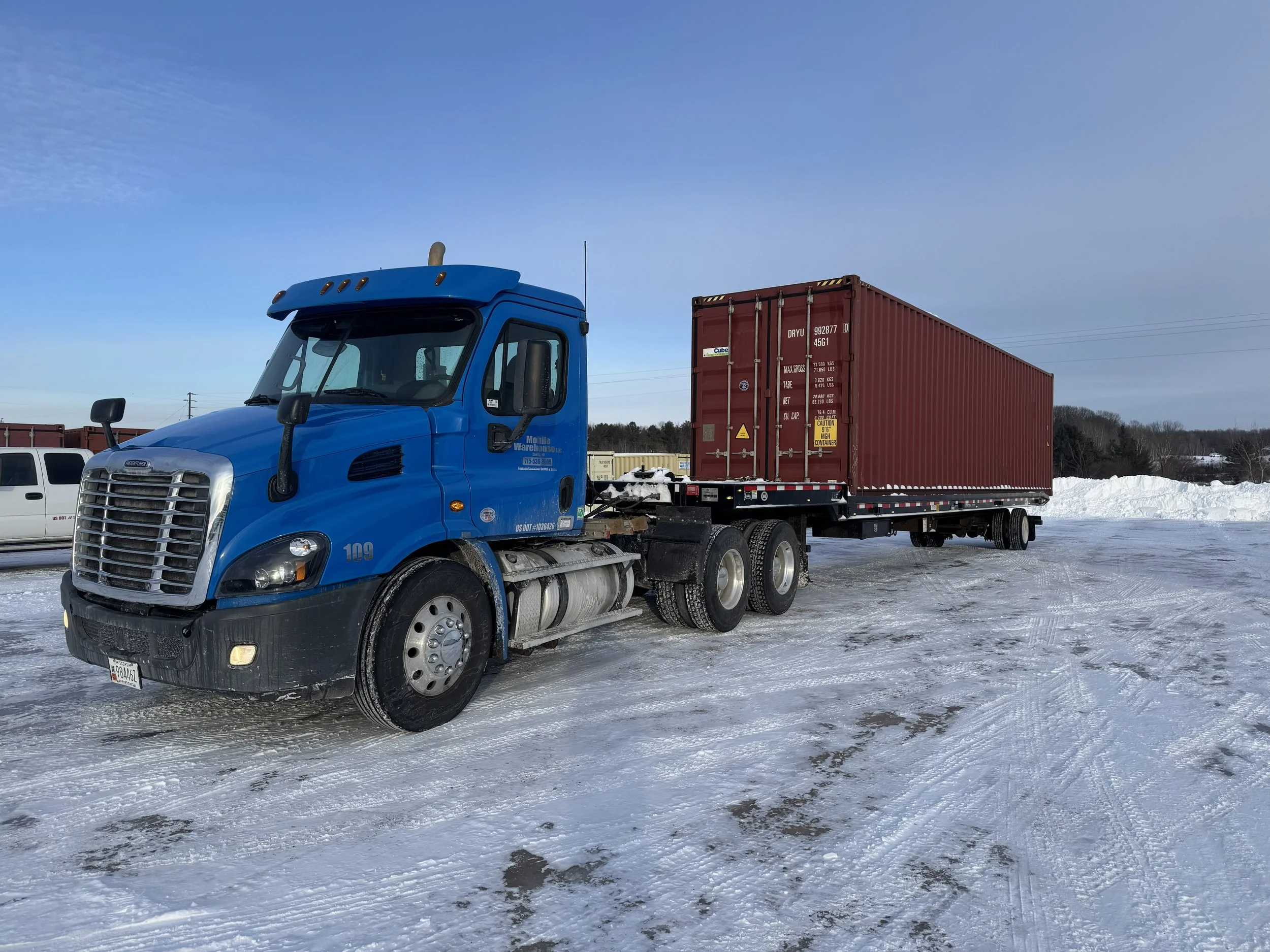 Mobile Warehouse Semi Truck with a red high cube shipping container loaded on trailer.