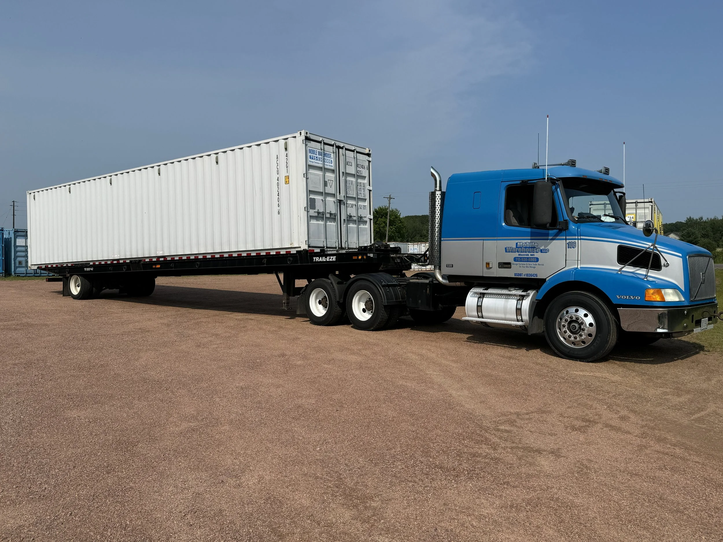 Mobile Warehouse's Volvo Sleeper Delivery truck with tilt bed delivery trailer and container loaded on the back.