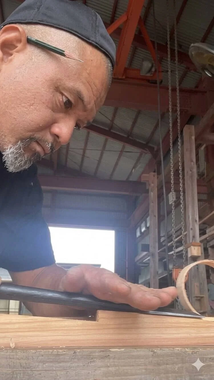 Japanese temple carpenter Kokichi Ozaki shaving wood with a chisel.