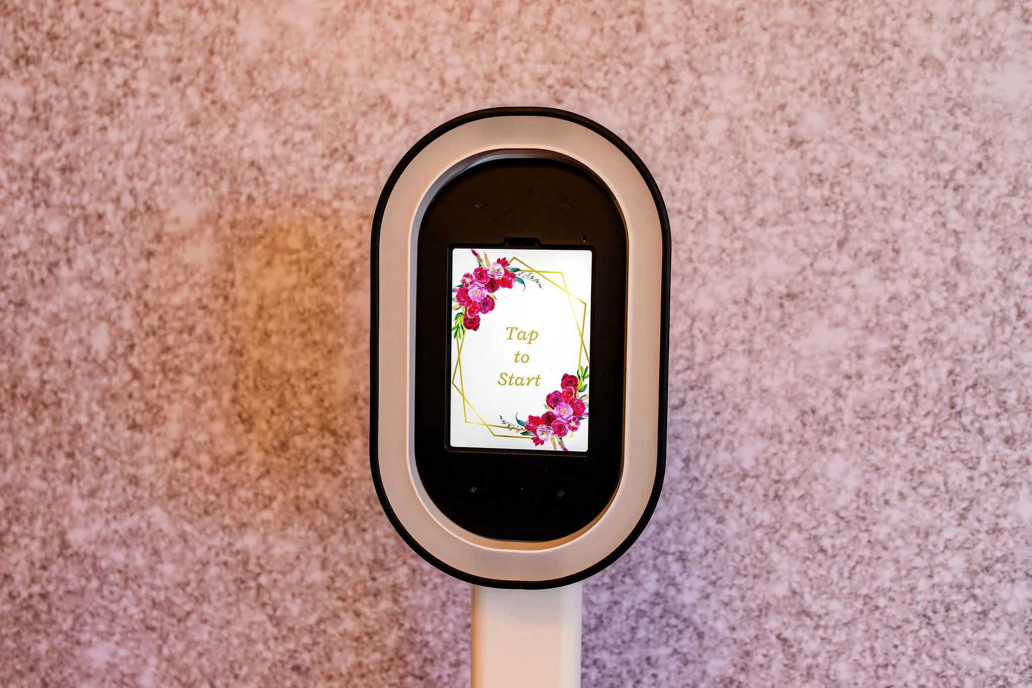 Touchscreen kiosk with floral design and the text 'Tap to Start' displayed on the screen