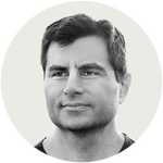 Black and white portrait of a man with short dark hair and a serious expression