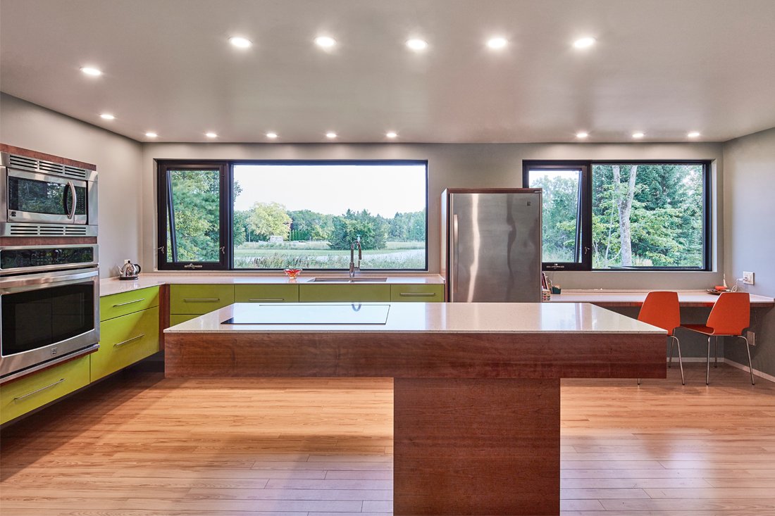 Central living/dining/kitchen space with large windows