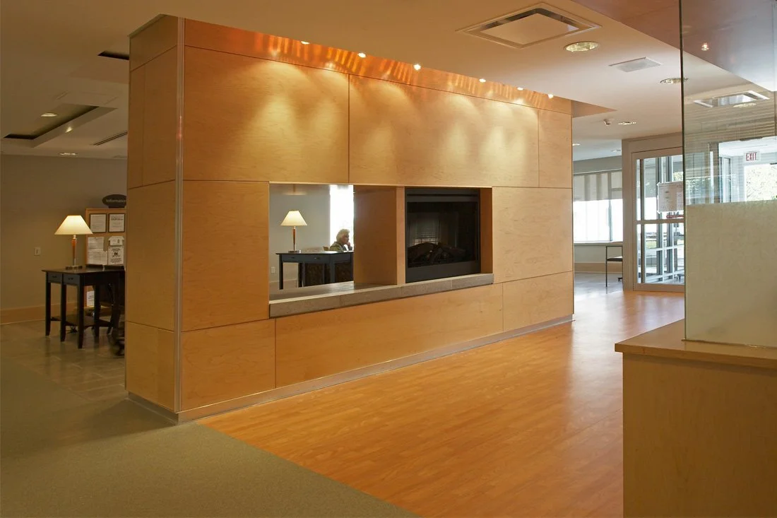 A grand hallway with a room divider wall with fireplace