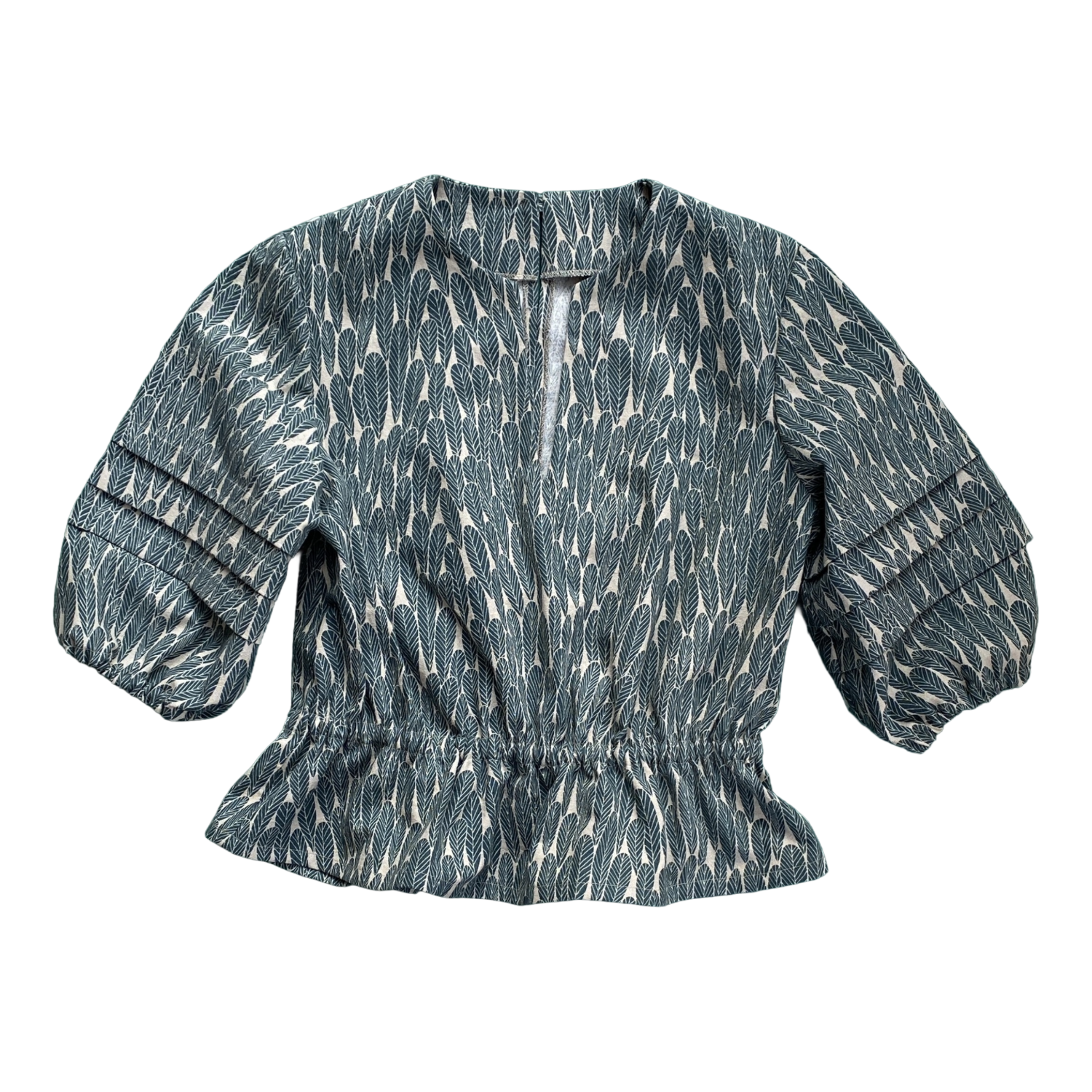 A women's top with a green and white leaf pattern, featuring a gathered waist, puffed sleeves with pleats, and a small keyhole opening at the neckline, laid flat.   Made with the Claudia Top Sewing Pattern from SewClothing.
