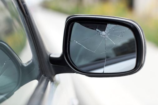 Side mirror on a car with a cracked glass.