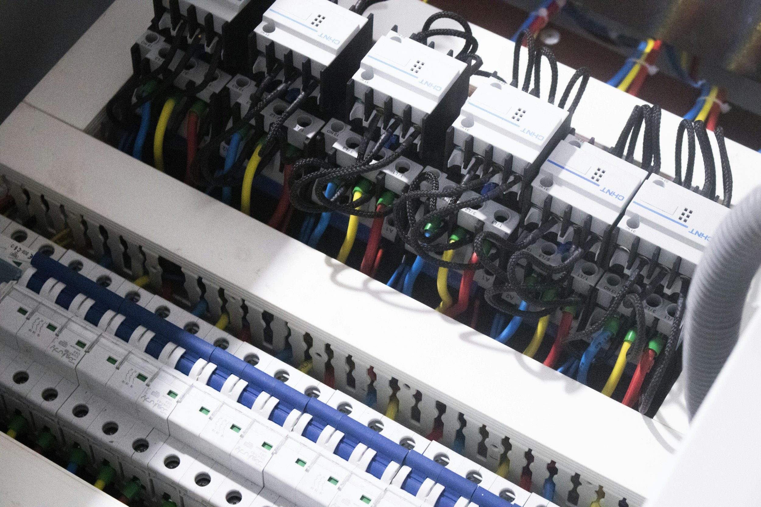 Close-up of an electrical control panel with circuit breakers, wiring, and other electrical components.