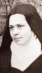 Black and white photograph of a young woman with dark hair, wearing a dark head covering and a light-colored blouse, facing slightly to the right.