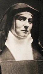 Black and white photo of a woman wearing a habit, likely a nun.