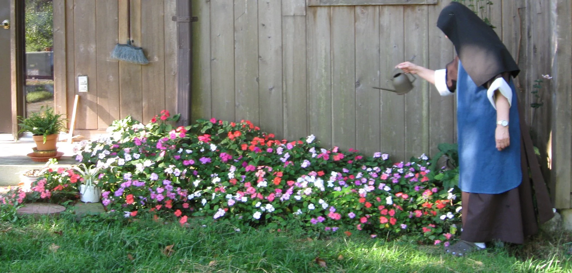 Nun watering flowers