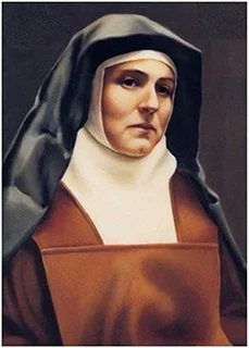 Portrait of a nun with a serious expression, wearing a black and white habit and brown clothing, against a dark background.