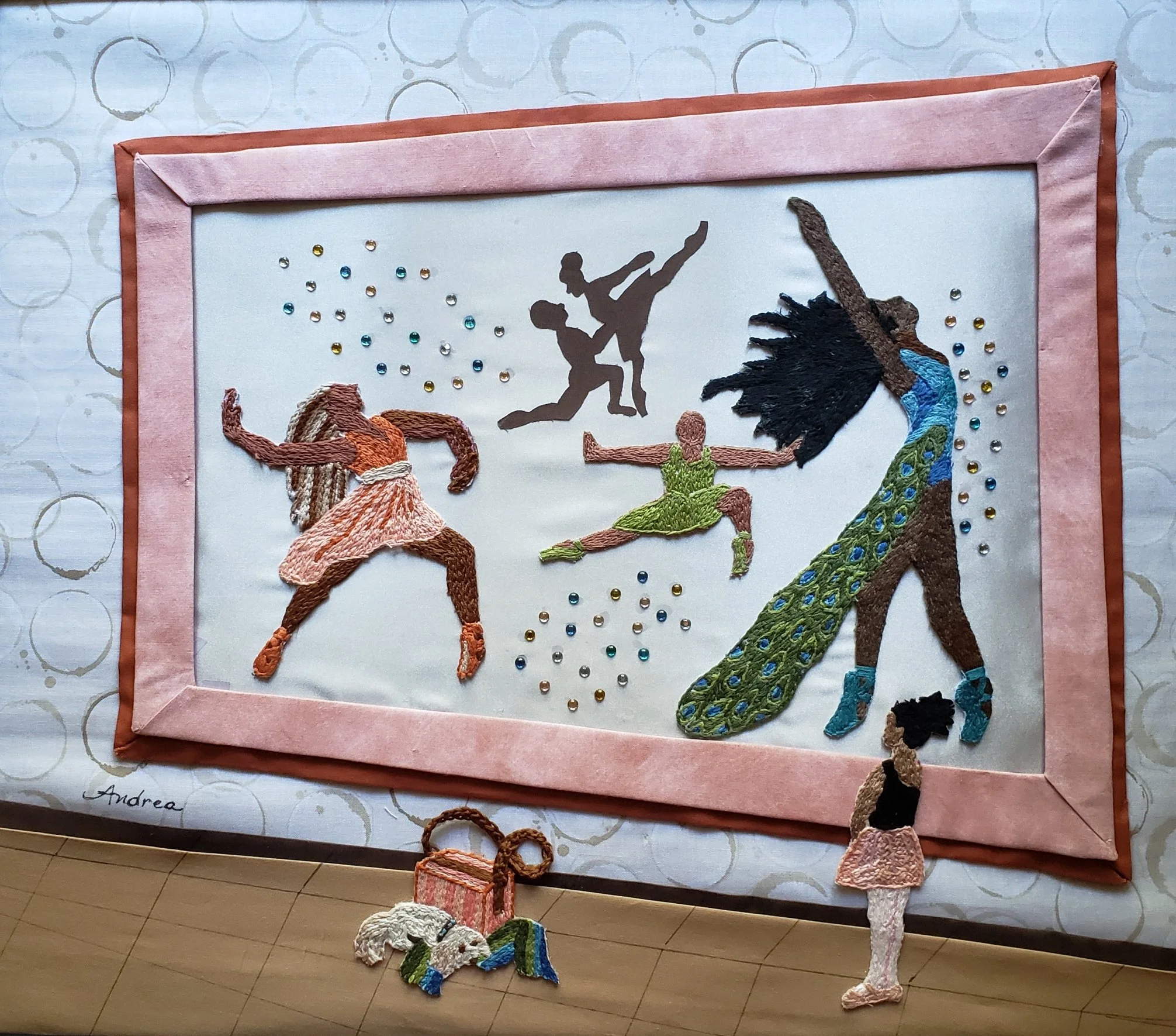artwork made of embroidery and applique featuring several figures dancing and a small girl admiring them