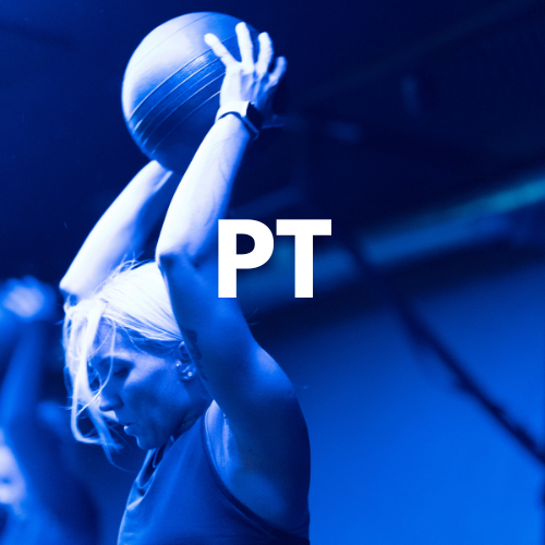 A woman exercising with a large exercise ball, labeled 'PT', in a gym setting with blue lighting.