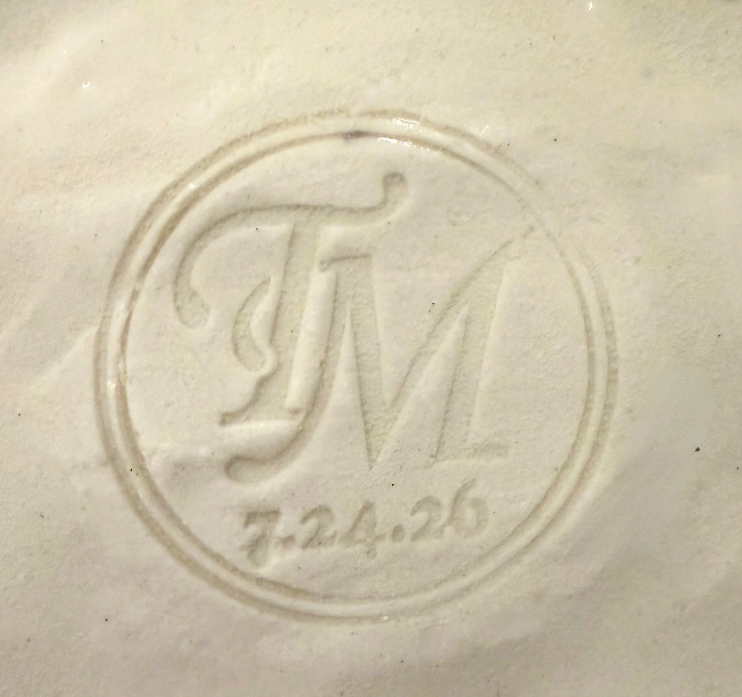 Close-up of an engraved number 2 on a light-colored surface.