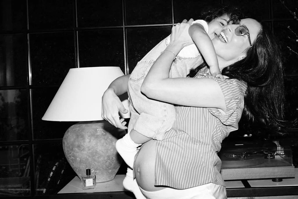 Woman wearing glasses holding a young girl in her arms.