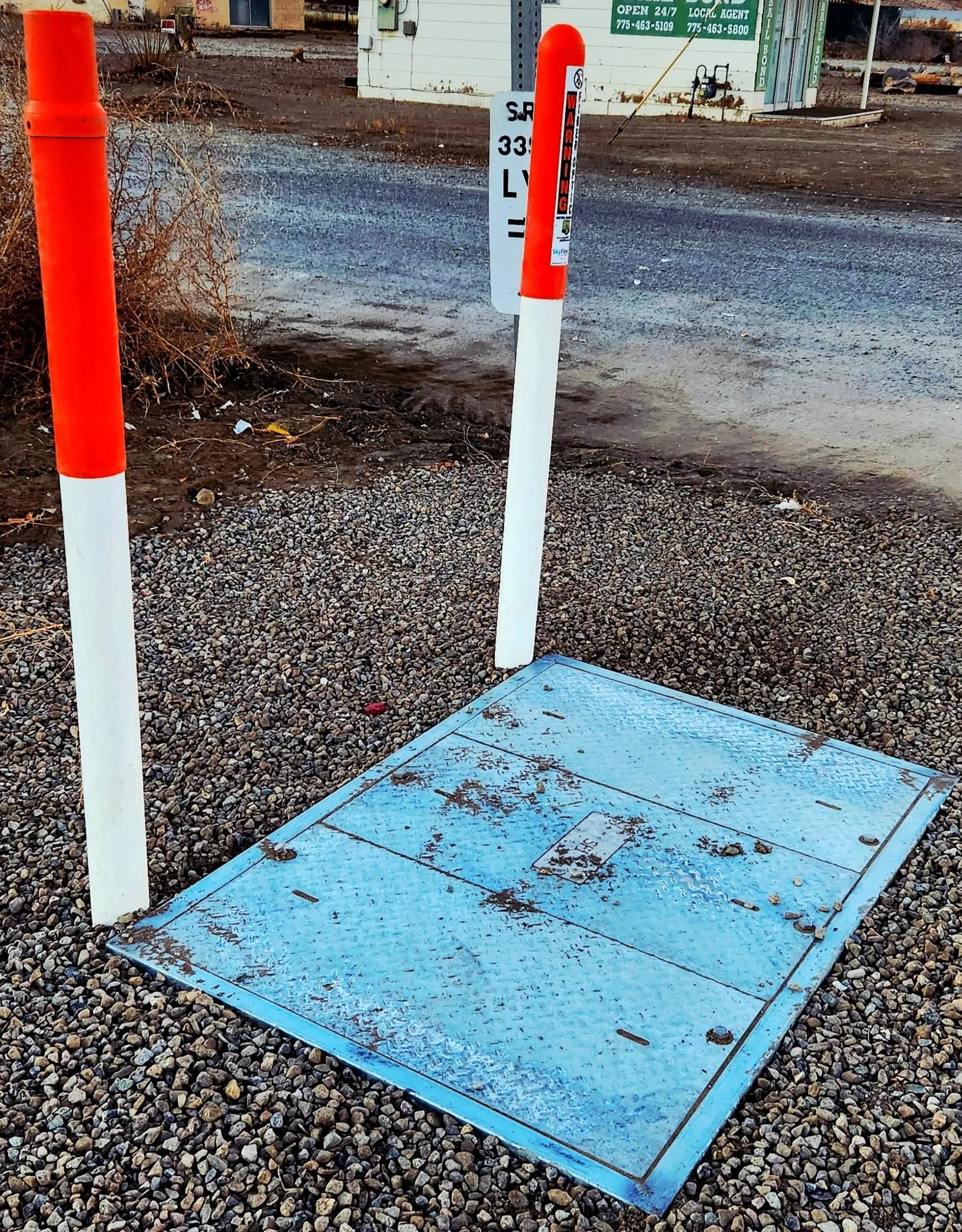 Fiber optic utility access box and safety bollards in Yerington, Nevada, representing local digital infrastructure.