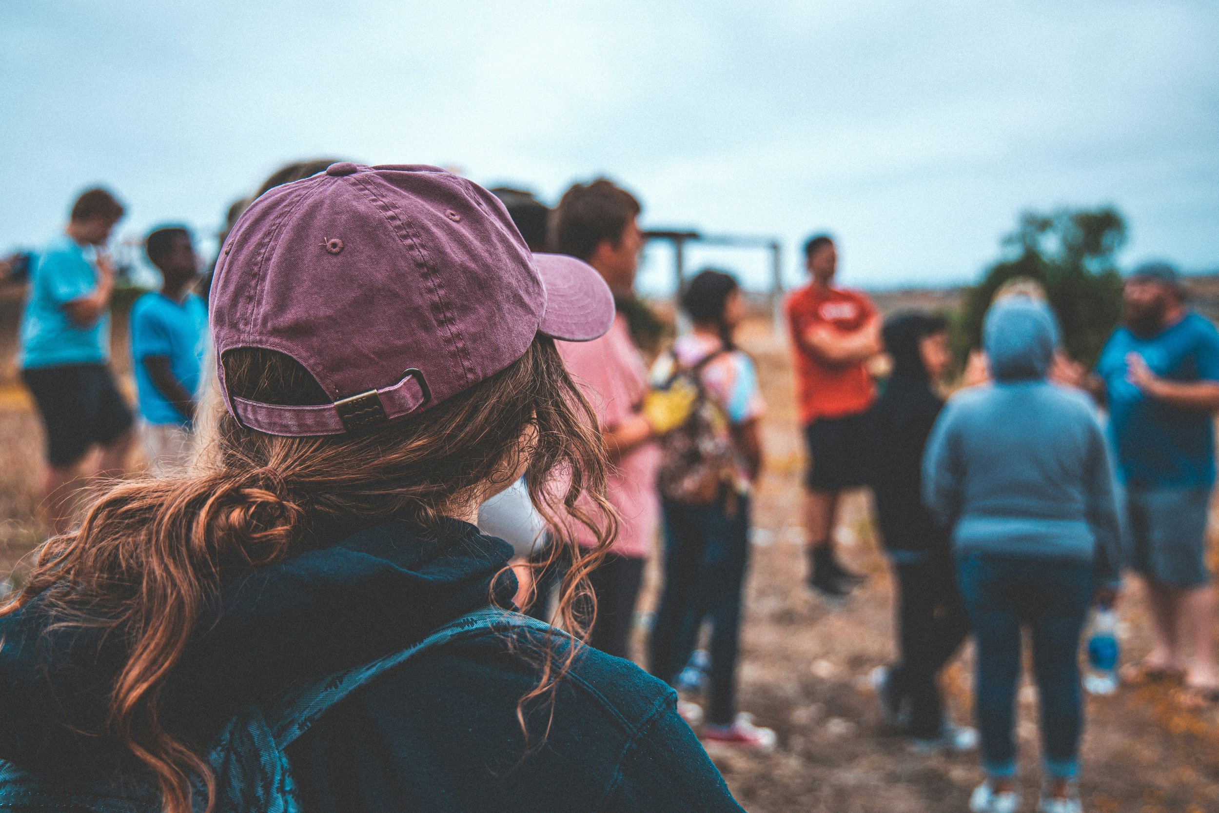 Woman standing apart from a group, feeling unseen