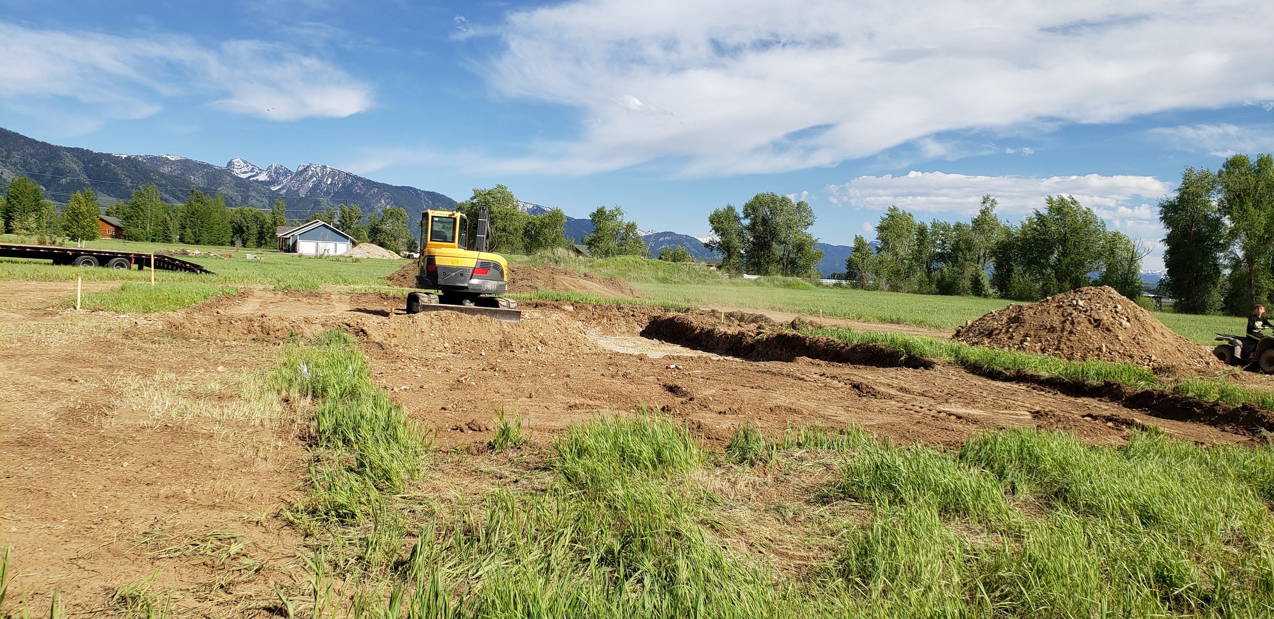 Image of mini excavator digging the foundation for a new home build in Star Valley Wyoming