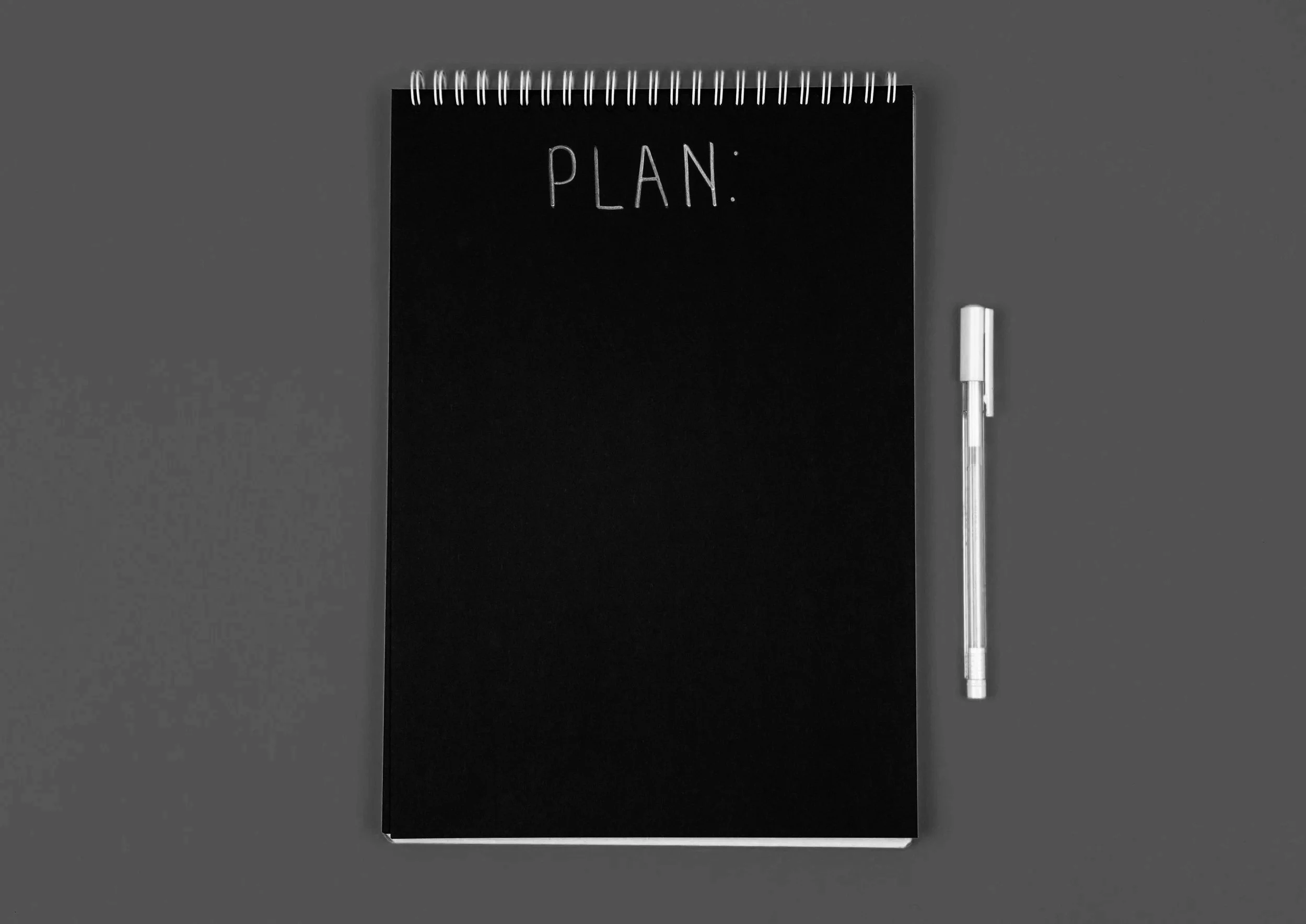 Image of an notebook titled "plan" with a pen beside it