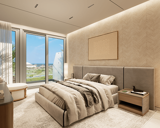 Modern bedroom with a large bed, nightstand, and floor-to-ceiling windows showing a view of the outdoors and ocean.