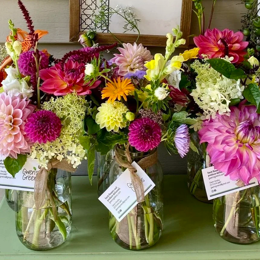 image of fresh bouquets in mason jars with ribbon tied around the mouth and an information card attached
