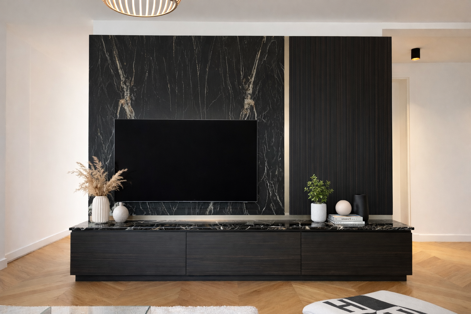 Un salon moderne avec un mur en marbre noir, un meuble TV noir, une télévision, et des décorations en vases et plantes.