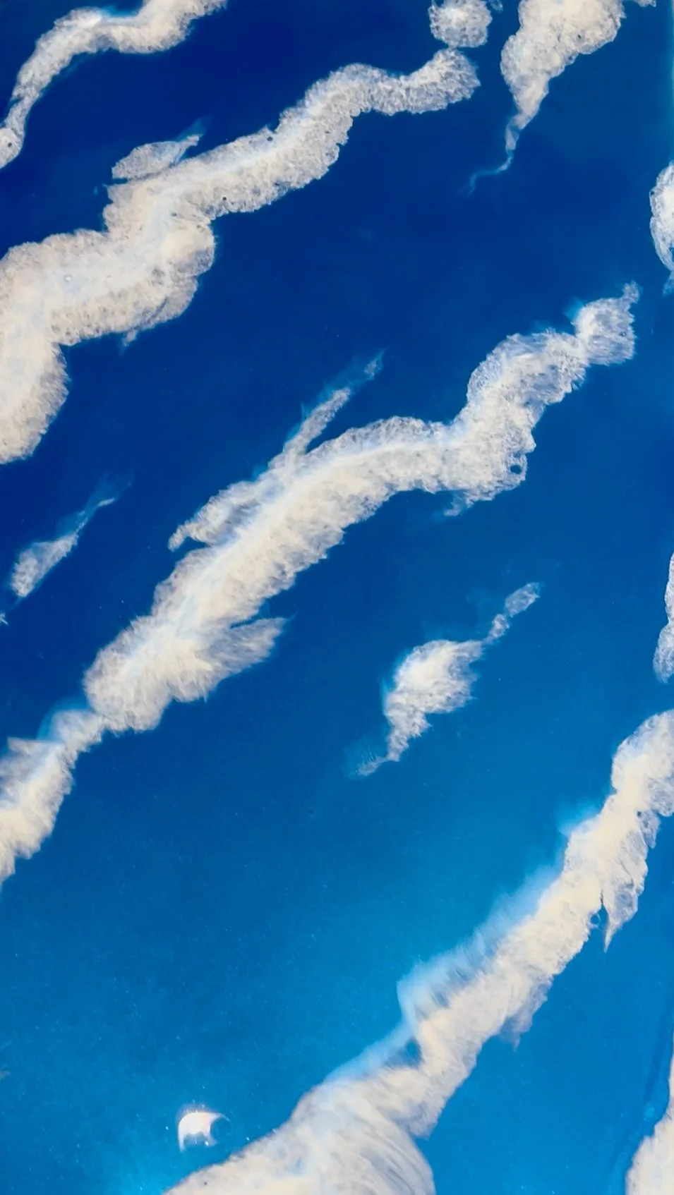 Custom metallic epoxy floor design mimicking blue sky with white clouds and contrails by Tru Epoxy Nation specialists.