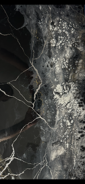 Close-up of custom metallic epoxy floor with black, gray, white, and gold marble veining by Tru Epoxy Nation.