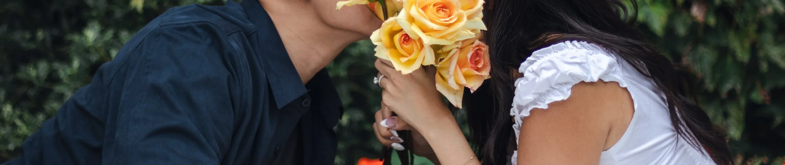 Woman presenting a bouquet of yellow roses to a man, suggesting a romantic gesture.