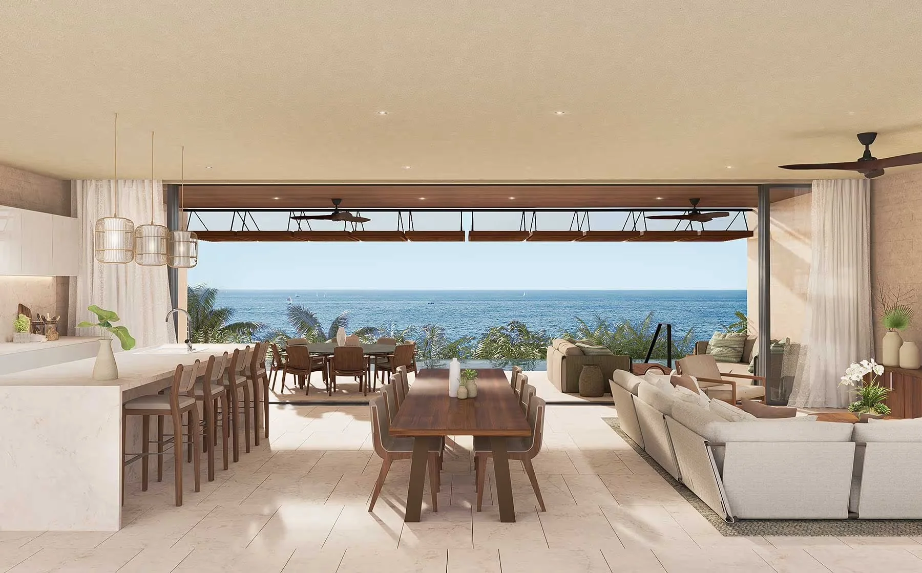 Open-concept living and dining area with large glass sliding doors leading to ocean view, featuring modern furniture, a long wooden dining table, beige couches, indoor plants, and ceiling fans.