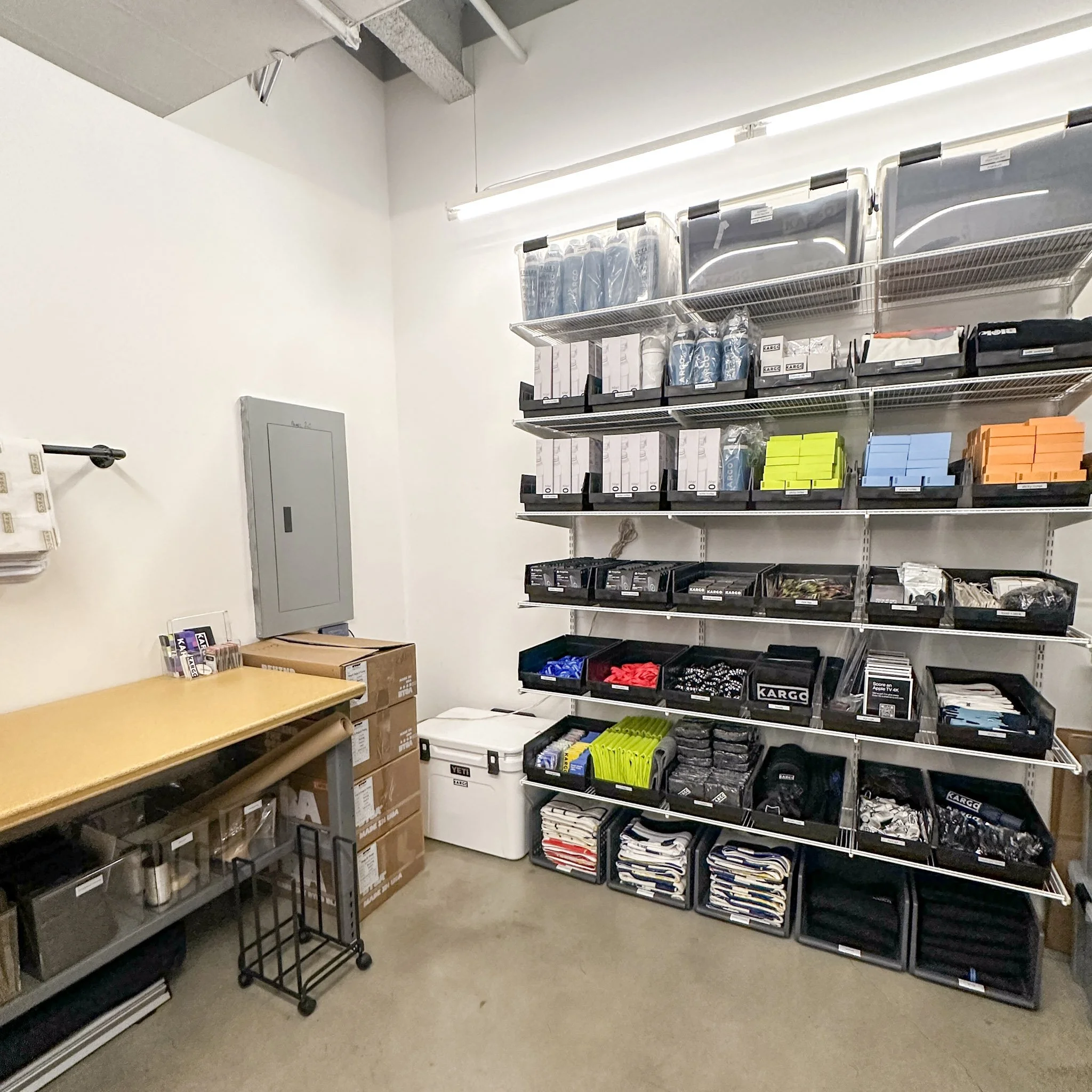 Store shelf with various items including boxes, binders, and tissue packages, in a retail or storage space.
