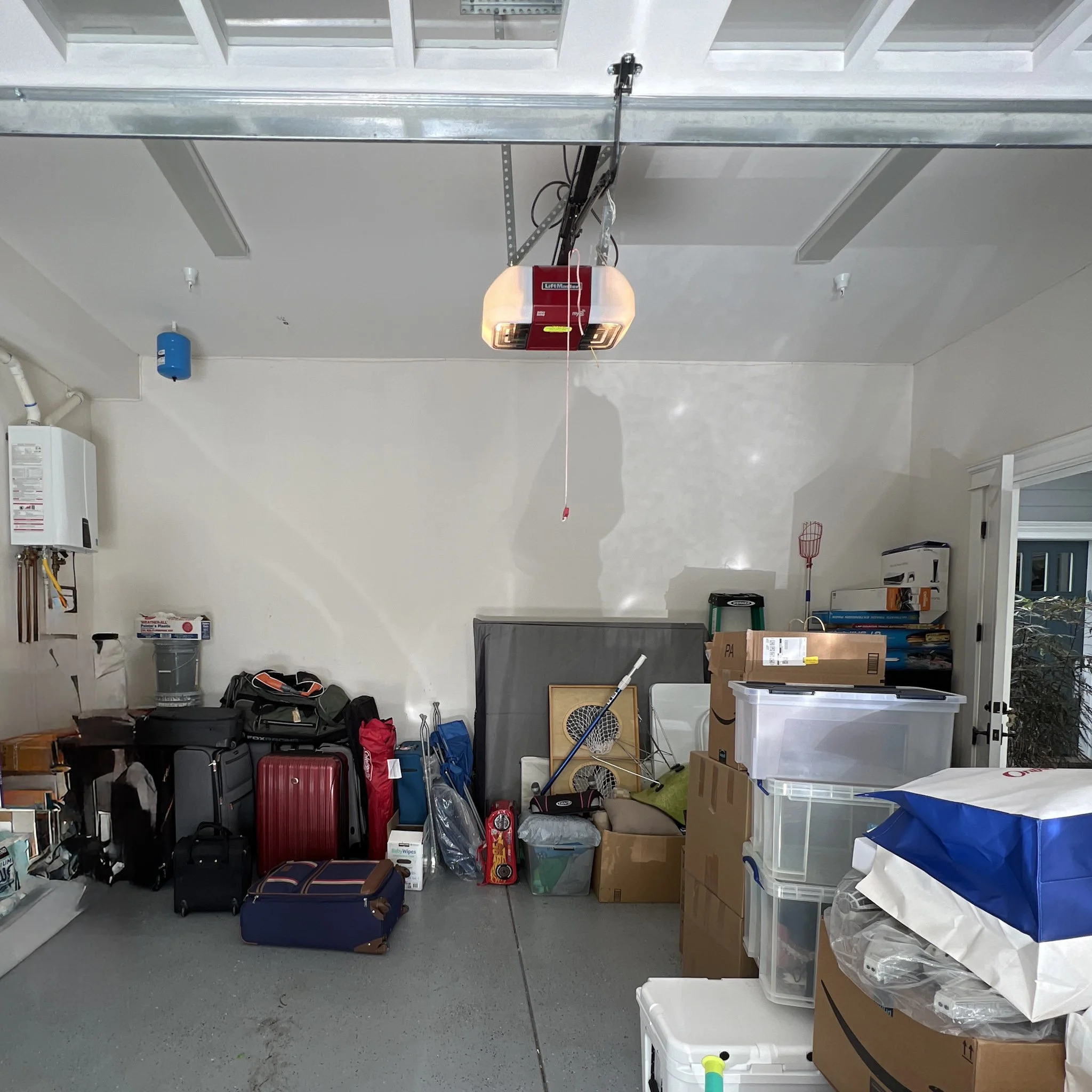 Garage with various boxes, suitcases, and household items stored on shelves and the floor.