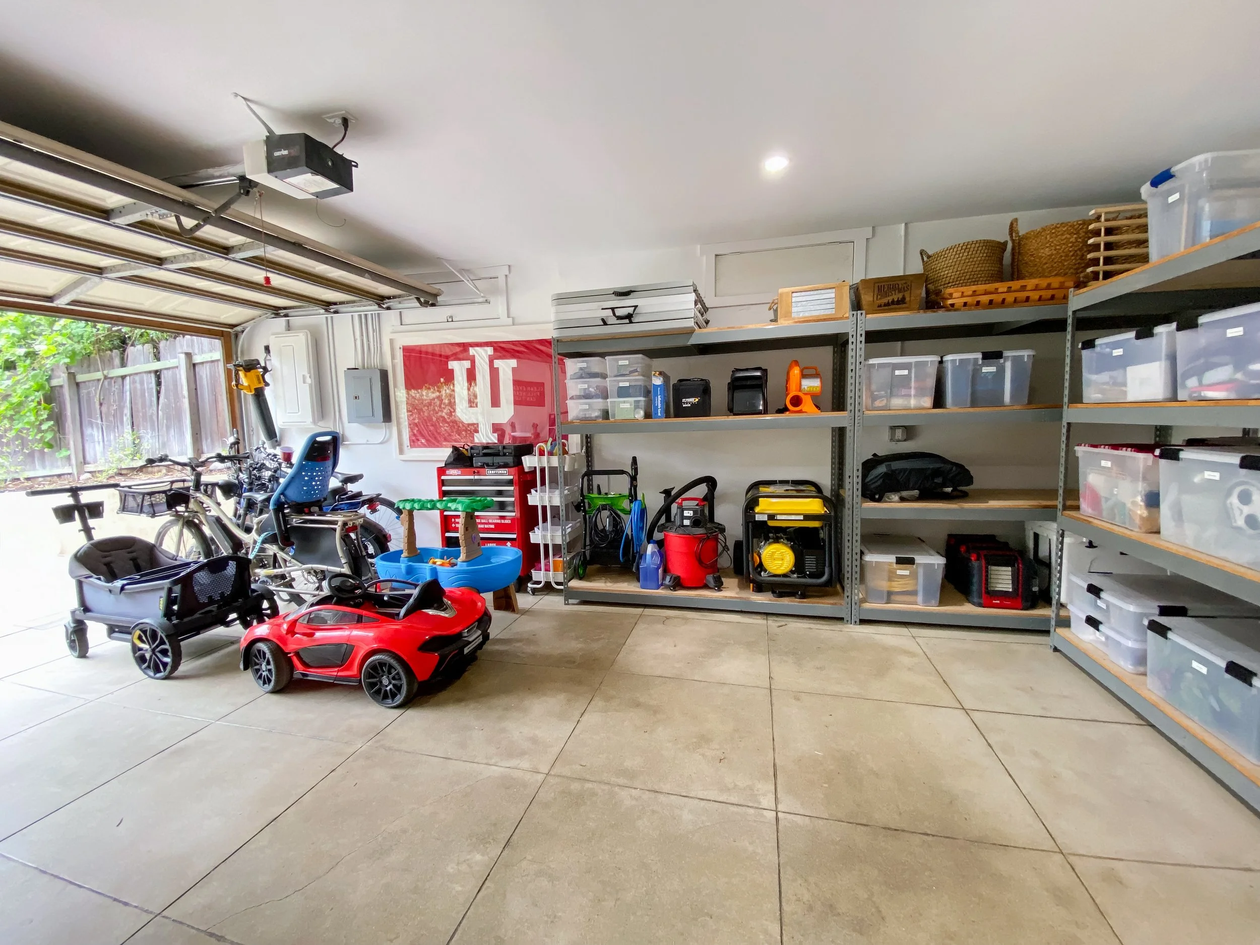 organized garage with shelves, wagons, bins, bikes, tools