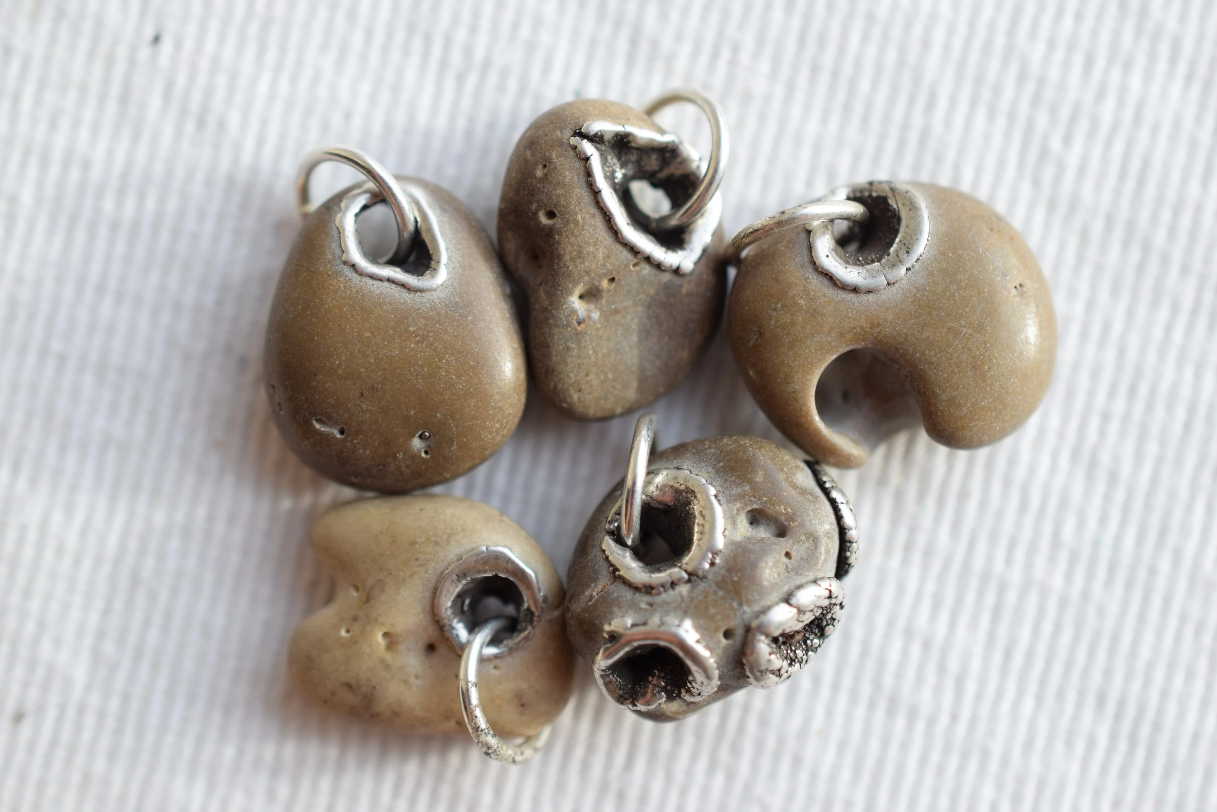Tiny hag stone charms made in 2016, inlayed with silver. 