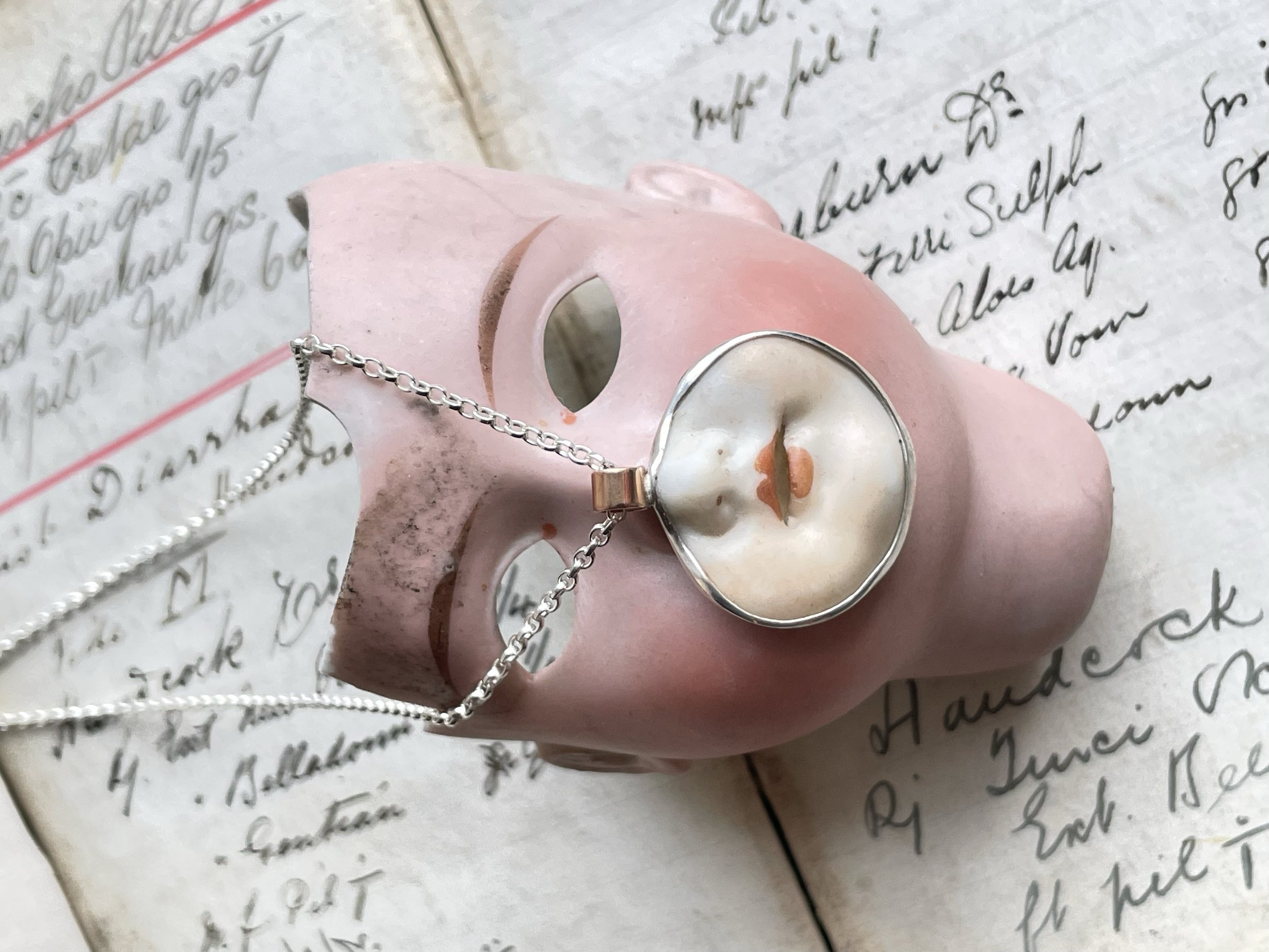 Silver pendant make with found antique porcelain doll face fragment 2022