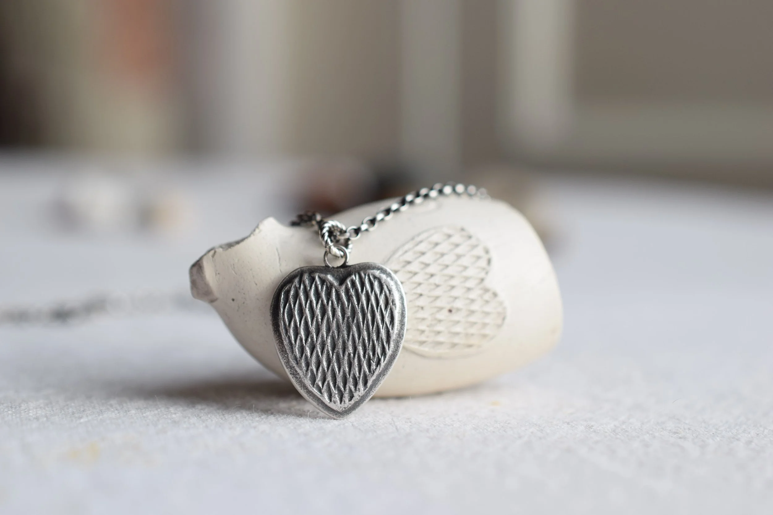 Silver necklace made from the impression of the design on a found Victorian clay smoking pipe.