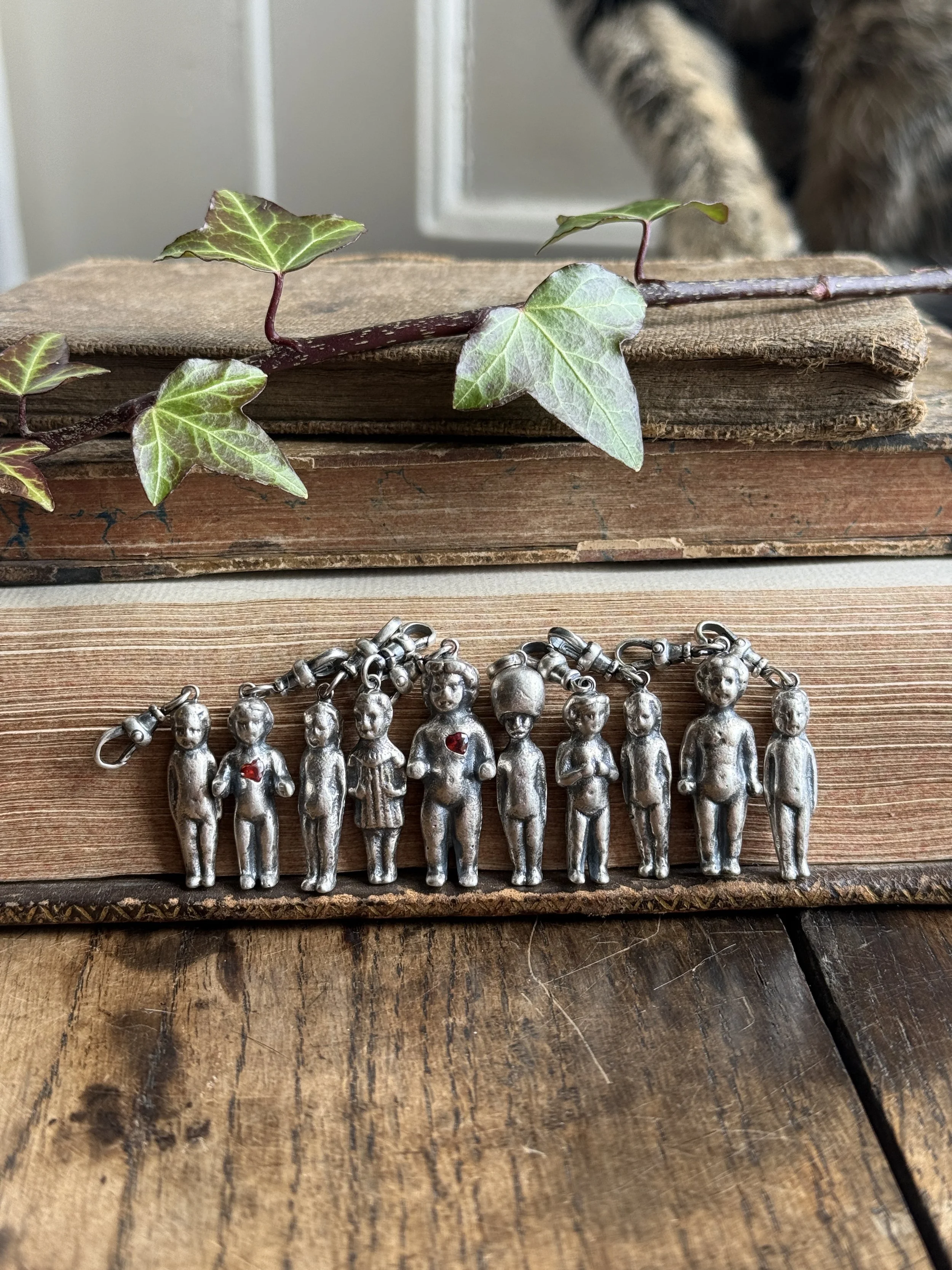 Collection of silver pudding/penny dolls/ frozen Charlotte charms cast directly from our finds. 
