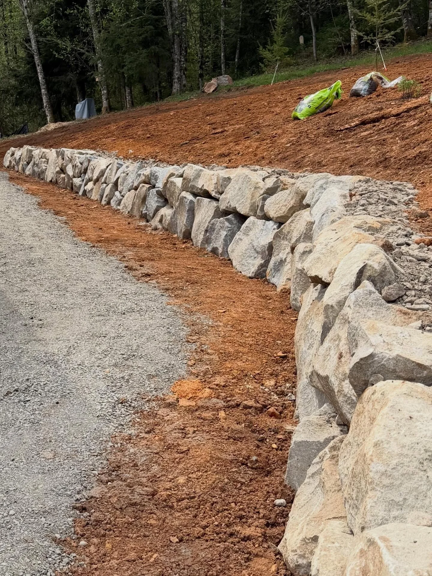 The boulder retaining wall is set! 
On these hillside lots, some terraces are nearly always necessary to settle a home into the land.  Sometimes we can find a balance between natural slopes, and strategic walls to minimize the cost impact, while maki