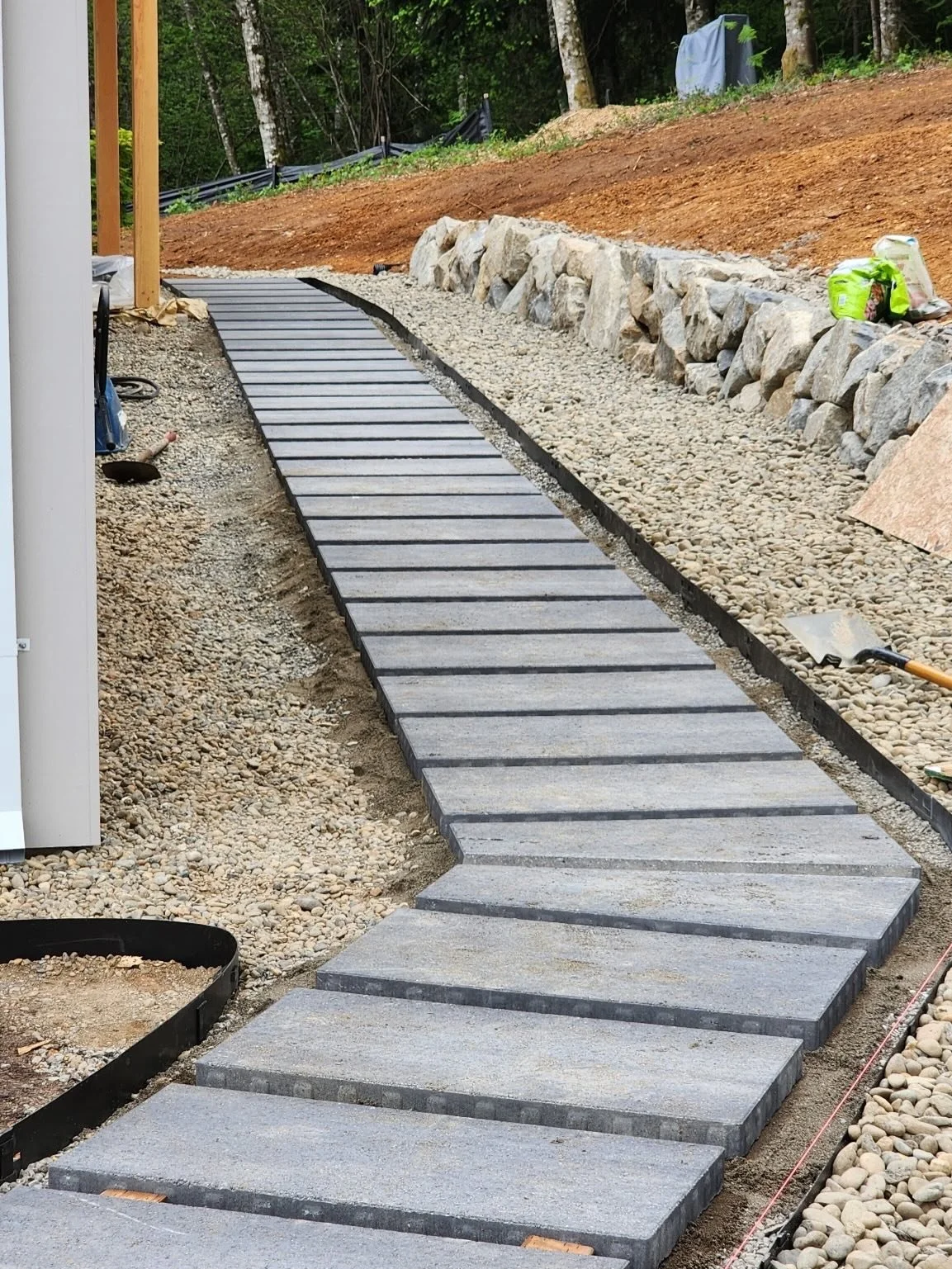 The team is making great progress on the outdoor living elements of this project!  The stepping stone path is nearly complete, and the surface is well underway on the back view deck.
