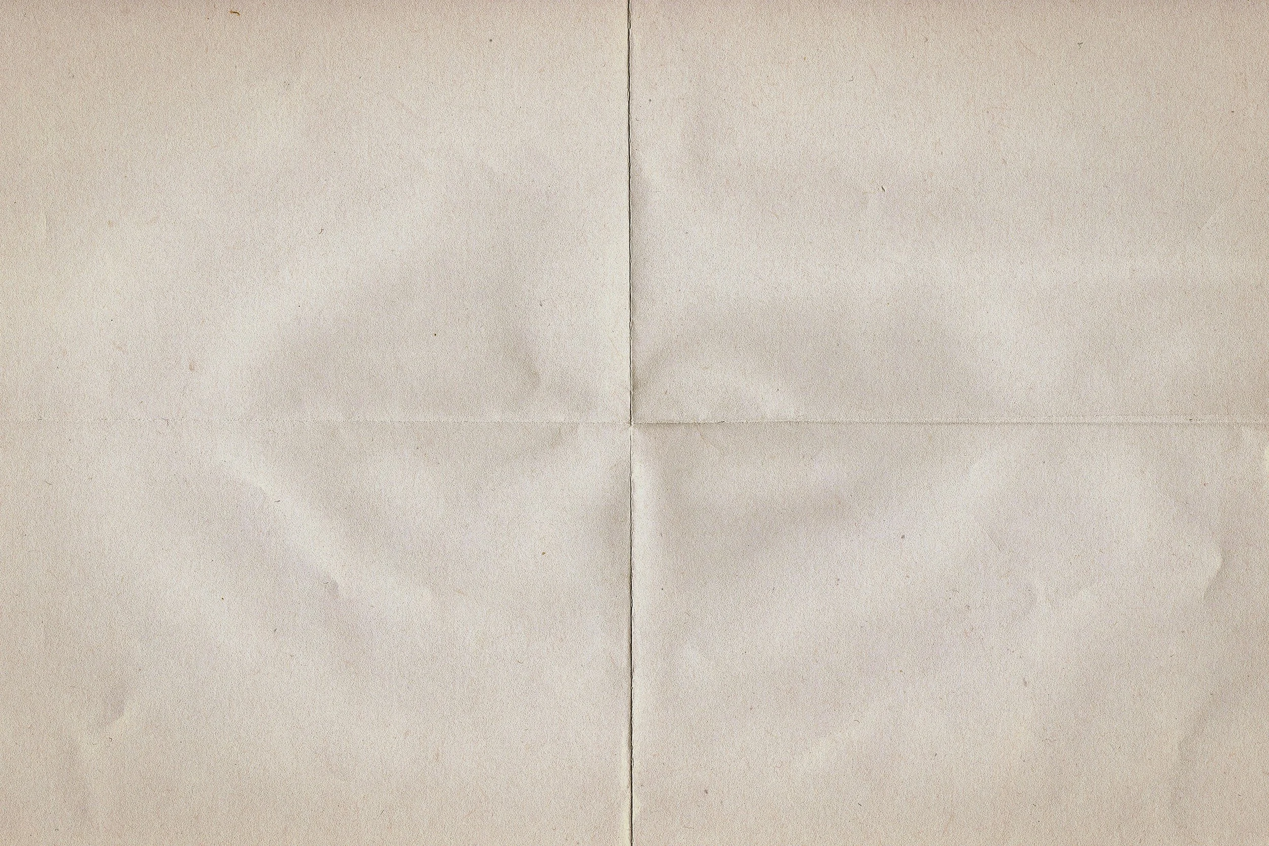 A beige sheet of paper with visible creases forming a cross in the center.