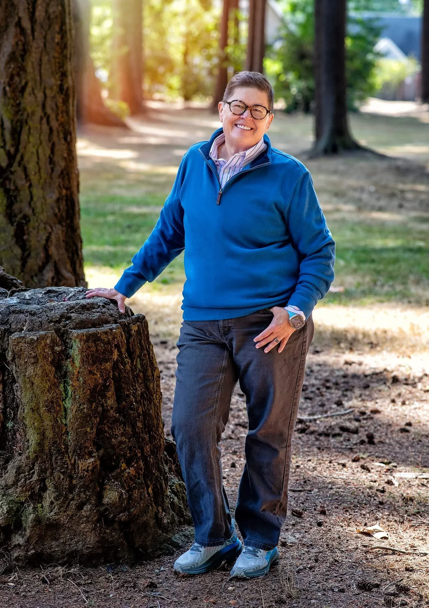 Dr. Dalton leans on a tree trunk